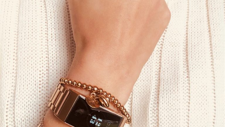 Fitbit on arm with multiple rose gold bracelets