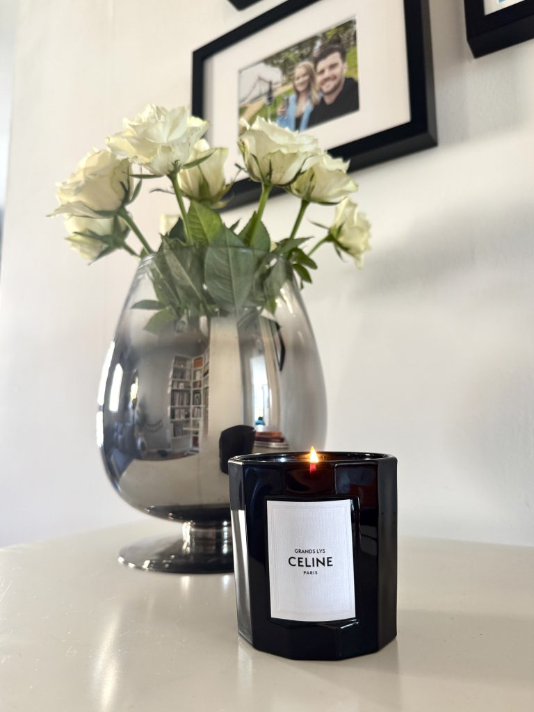 Romanticise your spring with the Celine Grand Lys candle with white roses in the background