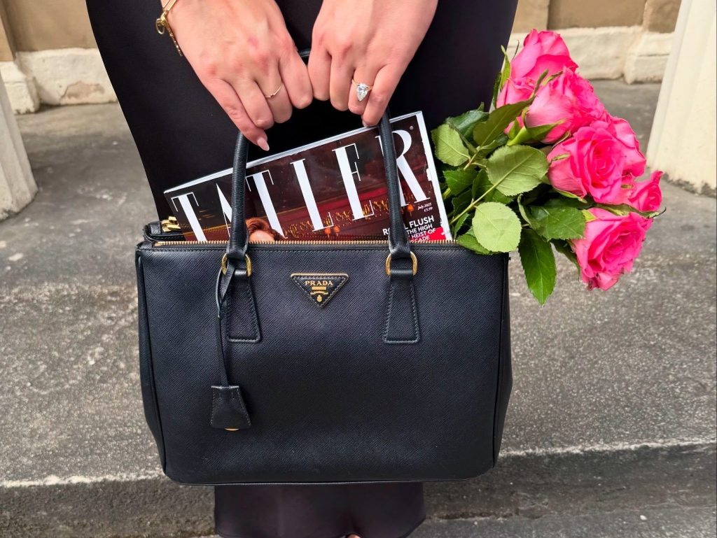elegant fashion - simple Prada handbag held by a woman with an engagement ring