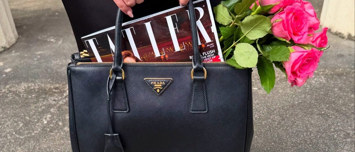 elegant fashion - simple Prada handbag held by a woman with an engagement ring