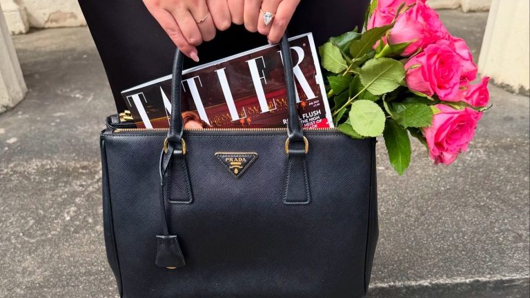 elegant fashion - simple Prada handbag held by a woman with an engagement ring