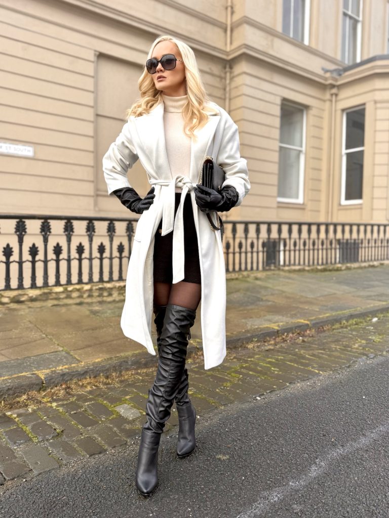 girl wears white coat with black bag, boots and gloves