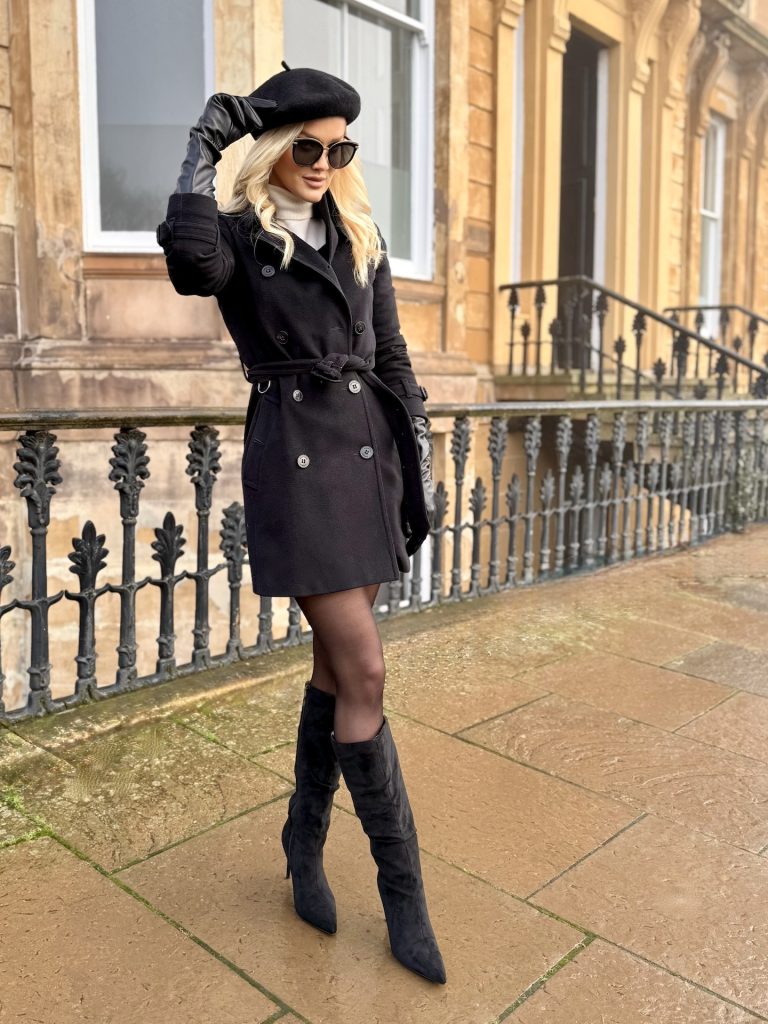 girl wears black Burberry double breasted coat with matching black beret and boots